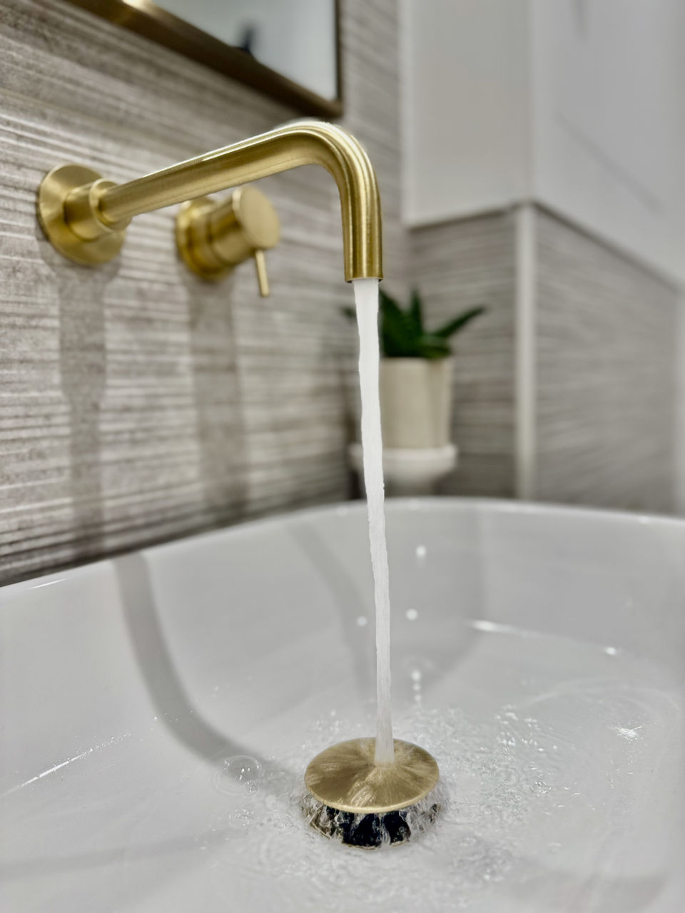 a brass tap with water running into the sink