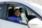 Smiling young driver in a car for community grant projects