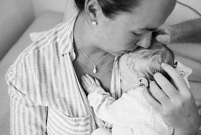 Mother kisses forehead of her baby after neonatal death.