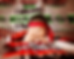 Sleeping baby with red headband on a colorful patterned blanket. A feather and turquoise beads nearby. Peaceful and serene setting.