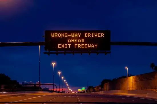 wrong way driver sign above freeway