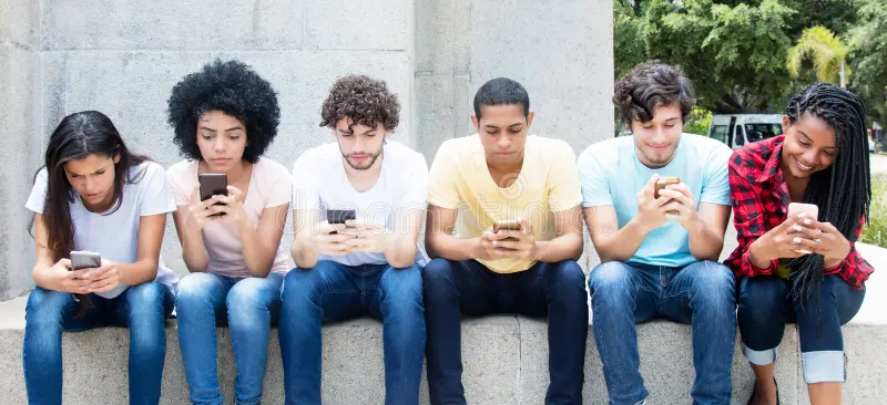 Six people sit on a stone ledge, focused on their smartphones. They're outdoors, wearing casual clothes in various colors.