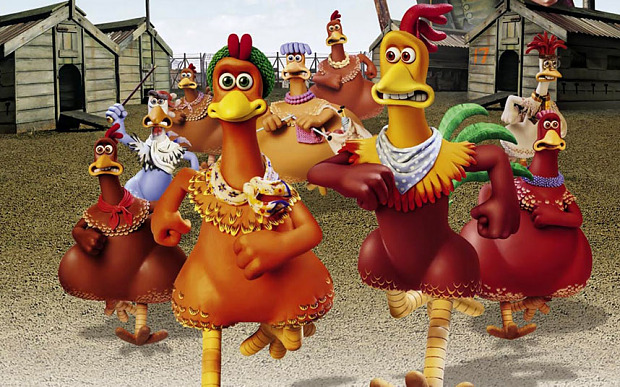 A group of animated chickens wearing clothes run determinedly in a farmyard with sheds in the background, creating a humorous escape scene.