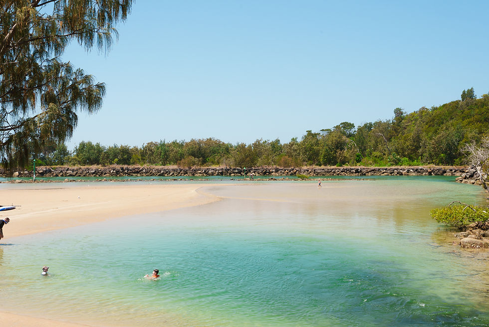 People in the water at a swimming hole, surrounded by rocks