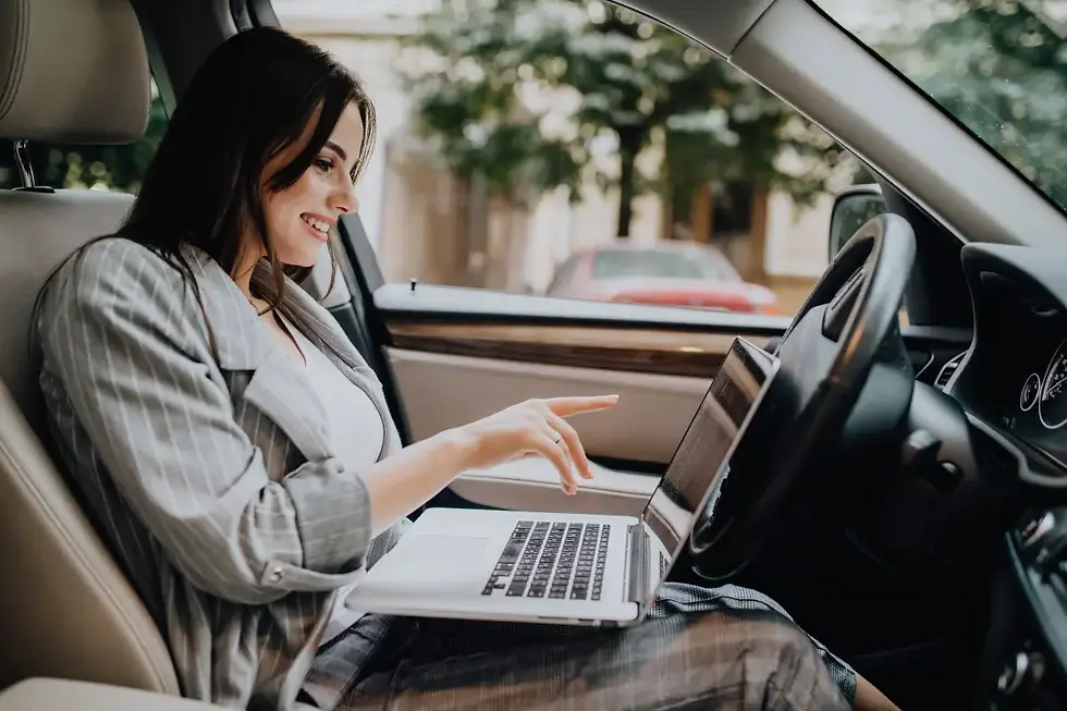 Woman sitting in her car with a laptop, thinking about does renters insurance cover theft from your car