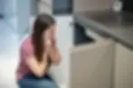 Woman looking worried in her kitchen after discovering possible water damage