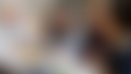 Adult learners discussing coursework together in a collaborative study session at a library.