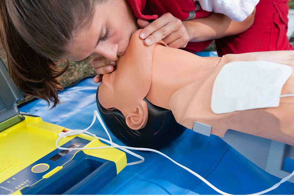 "Learn essential first aid techniques with our training program. This image shows a woman providing rescue breaths to a manikin, demonstrating the correct technique for administering CPR. Our First Aid courses provide comprehensive training in lifesaving techniques like this one, equipping you with the knowledge and skills to confidently respond to emergency situations. Sign up for our training program today and make a difference in someone's life."