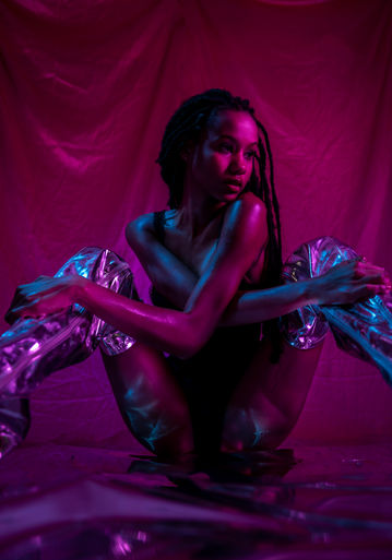 a woman is kneeling down wearing a pair of silver boots