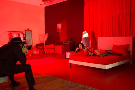 a woman in a red dress is laying on a red bed