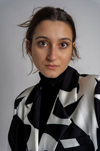 a woman wearing a black turtleneck and a black and white jacket