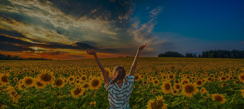 Woman standing in a field of sunflowers giving thanks to God.