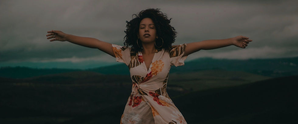 Woman standing in nature giving thanks to God.