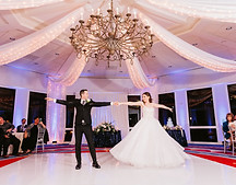 Bride and groom perform a choreographed first dance in front of friends and family on their wedding day.