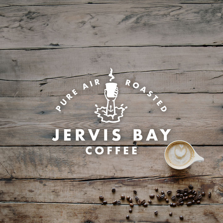 white logo on timber background with coffee beans