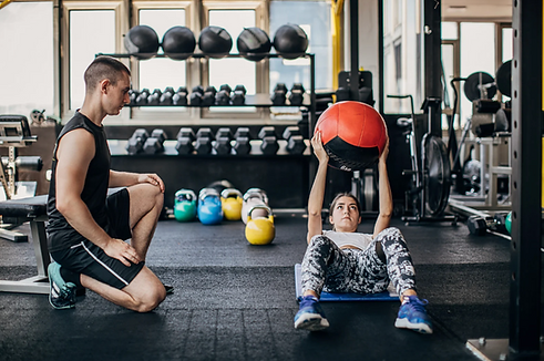 Supportive postpartum fitness Sydney personal trainer with client holding medicine ball