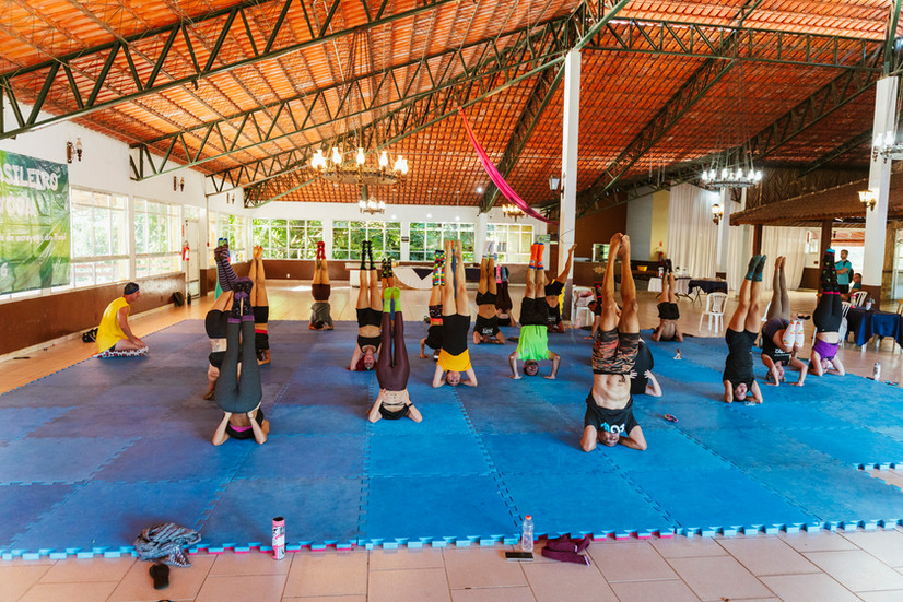 Turma de yoga fazendo invertida sobre a cabeça