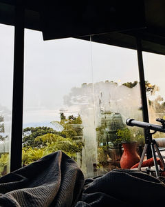 Telescópio apontando para janelão de vidro