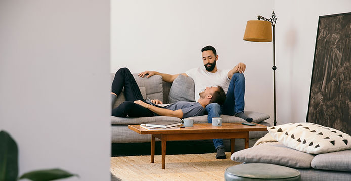 Same sex couple lounging in their home.