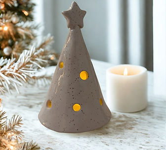 White clay tree luminary with some speckles in the clay, and a soft glow coming from inside.