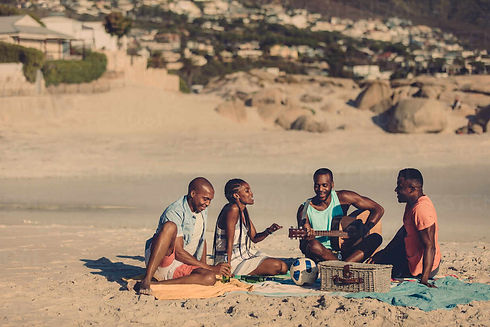 group-of-friends-with-guitar-sitting-on-beach-african-people-enjoying-at-the-seaside-picni