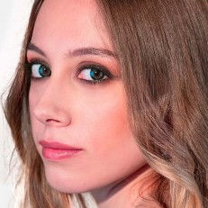 Thumbnail: model wearing Adore Dare Green colored contact lenses