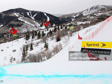 Three ski cross competitors jumping on a course