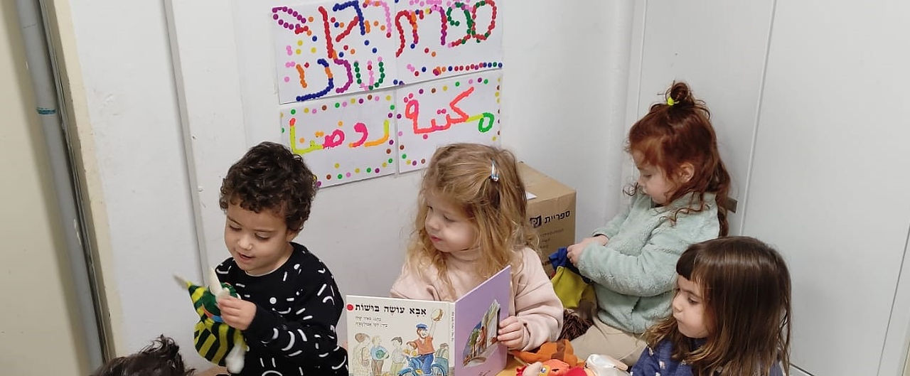 ילדים קוראים ספר ומחשקים