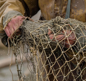 2400-close-up-of-a-fisherman-s-hands-mending-a-fishing-net-with-meticulous-care-and-skill.