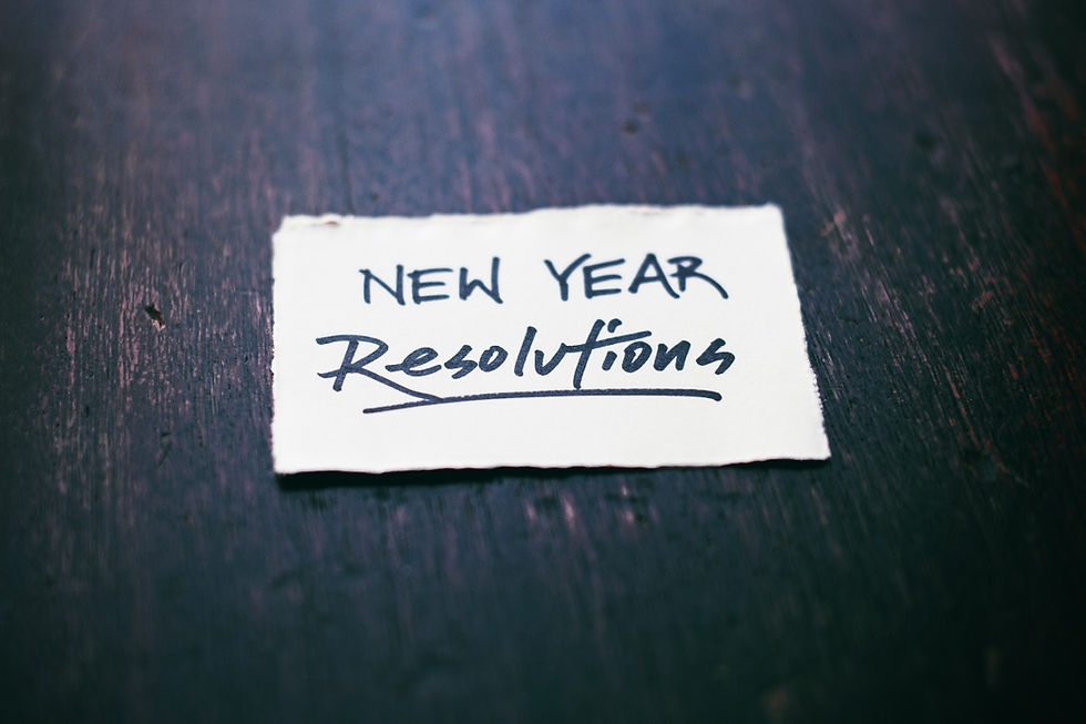 piece of paper on wood with words new year resolution on