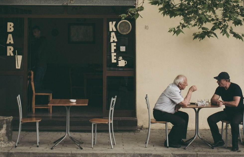 Two men sitting outside a coffee shop