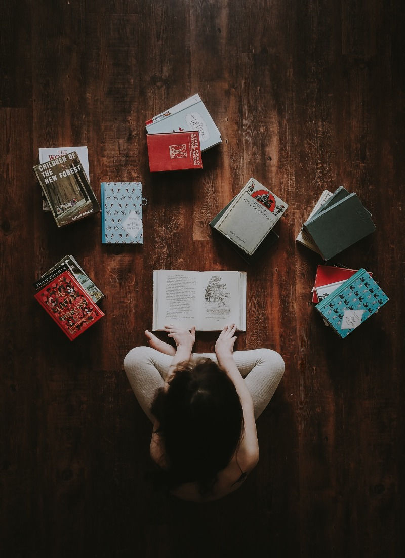 woman sitting with book around her