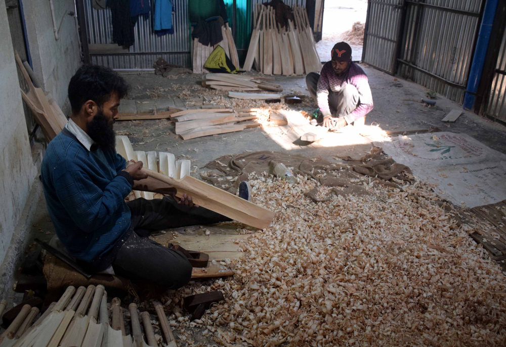 A worker checks the final shape of the bats