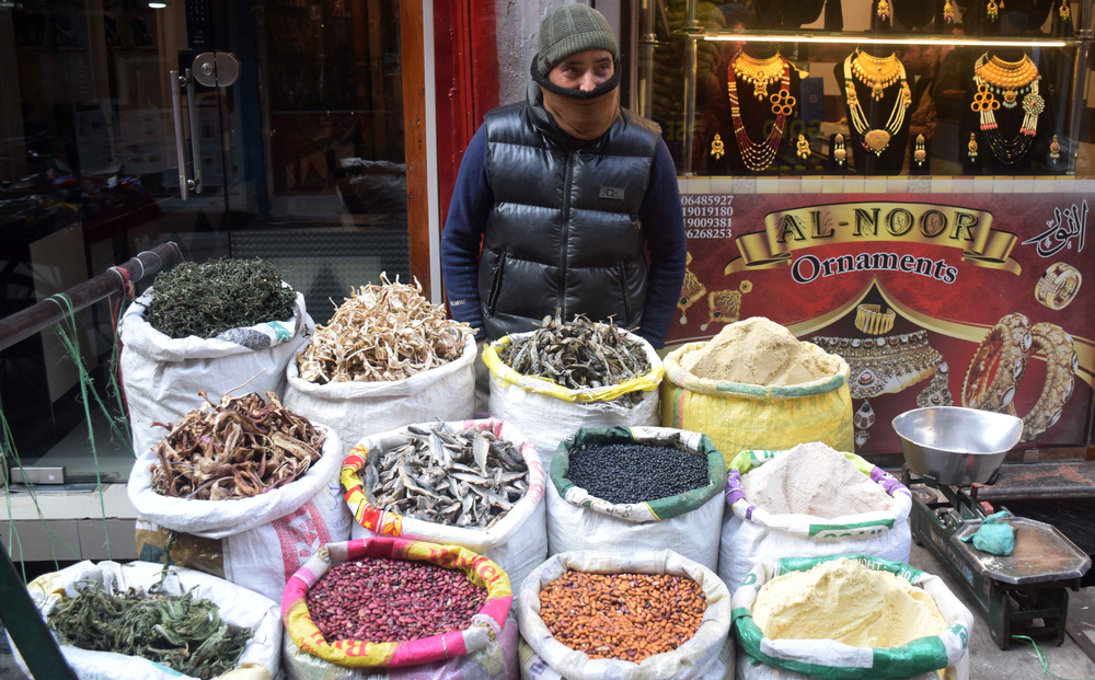 A vendor selling sun dried vegetables and beans on his cart
