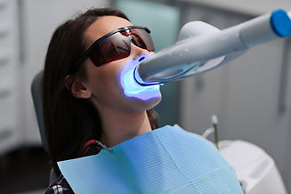 Close-up portrait of a female patient at dentist in the clinic. Teeth whitening procedure