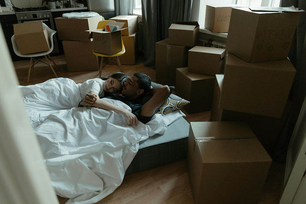 couple surrounded by boxes on the bed