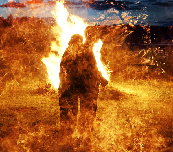 Two shadows standing in front of a bonfire: they appear to be consumed by flames.