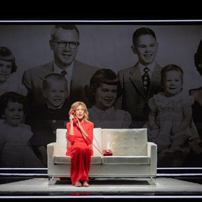 Christine Lahti on stage sitting in front of projected family photo