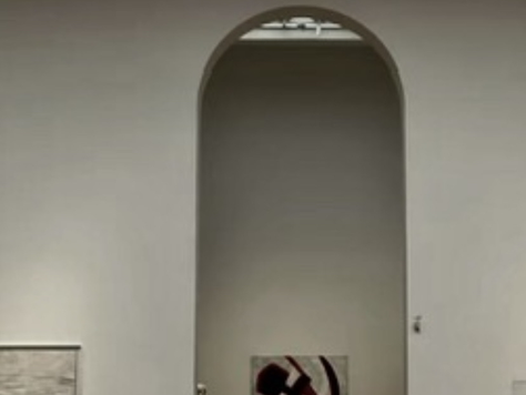 Photo: painting of a hammer and sickle framed inside an arch, in a gallery in Vienna.