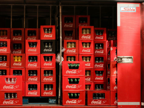 Red crates of coca-cola products piled high