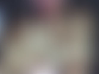 The band Katseye groups together smiling on stage in all white outfits.