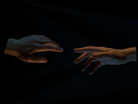 Two people reaching for each other.