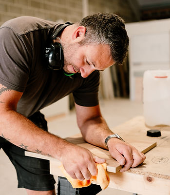 Craftsman sanding wood in workshop