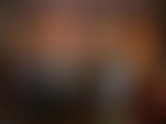 Eine Gruppe von Frauen posiert gemeinsam in einem Innenraum für ein Foto. Sie stehen eng beieinander, lächeln in die Kamera und sind modisch gekleidet; im Hintergrund hängt ein großes Porträt an der Wand.