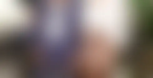 Zwei Frauen stehen nebeneinander in einem Wohnzimmer, vor ihnen sitzt ein kleiner Hund.