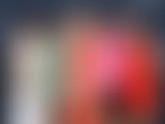 Gruppe von fünf Frauen in bunten Kleidern posiert auf einem Event vor einer Fotowand.