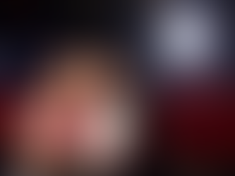 Mutter und Tochter sitzen im Kino, schauen begeistert auf die Leinwand und essen Popcorn, während das Licht des Films ihr Gesicht beleuchtet.