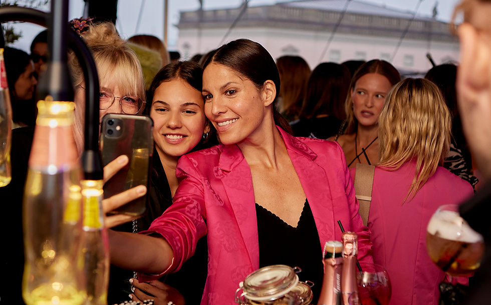 Besucherinnen beim Austausch auf dem FRAUEN100 Empowerment-Event, Abendstimmung und Event-Atmosphäre beim FRAUEN100 Networking-Abend, Speakerin auf der Bühne beim FRAUEN100 Frauen-Event unter freiem Himmel