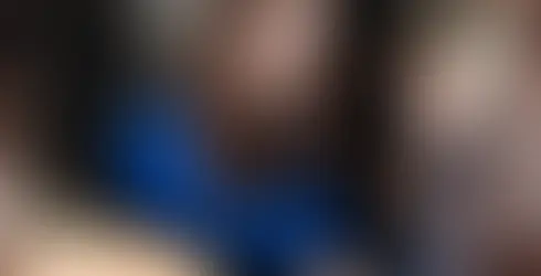 Frau im blauen Blazer unterhält sich lächelnd mit einer anderen Frau inmitten einer Event-Szene.