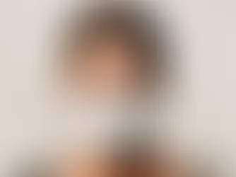 Porträt einer Frau mit zusammengebundenen Haaren, die direkt in die Kamera blickt und eine weiße medizinische Maske trägt, auf der der Schriftzug „#TheLoudestVoices“ steht.